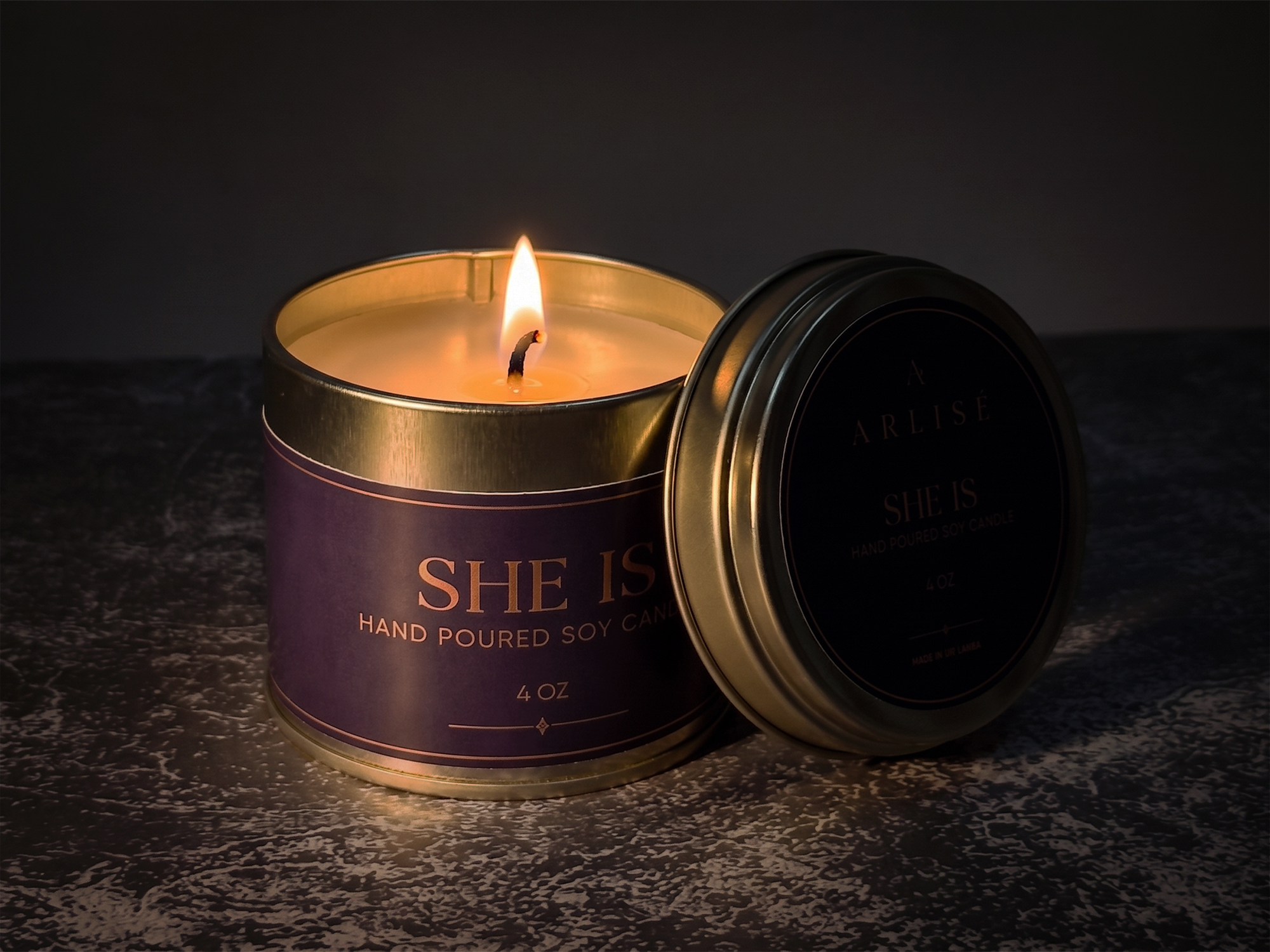 SHE IS Ceylon cinnamon leaf soy candle burning in a darkened room
